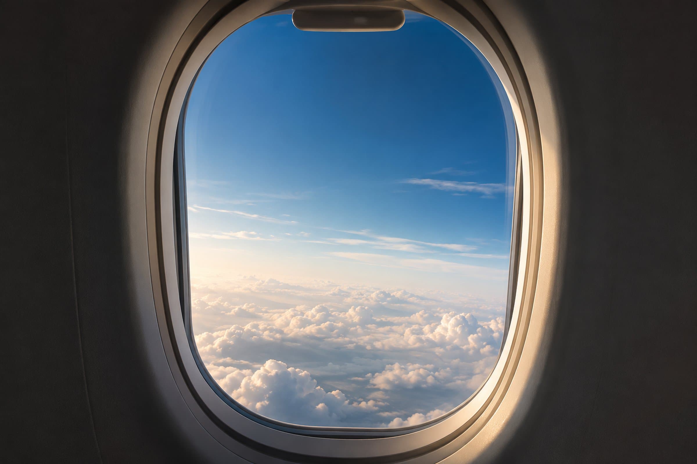 View of clouds and blue sky from an airplane window